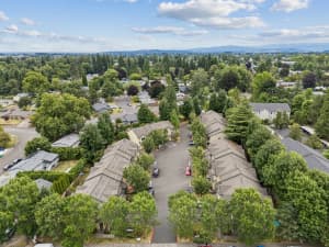 Aerial view of townhomes surrounding a central drive amid mature trees at Roberts Court Townhomes in Gresham, Oregon