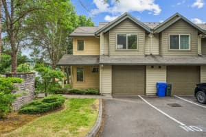 Two-story townhomes with gabled roofs, attached garages, and mature landscaping at Roberts Court Townhomes in Gresham, Oregon