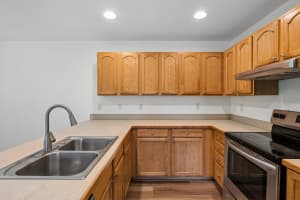 Kitchen with oak cabinets, beige counters, and a double-basin sink at Roberts Court Townhomes in Gresham, Oregon
