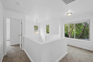 Carpeted landing with half walls and large windows overlooking trees at Roberts Court Townhomes in Gresham, Oregon