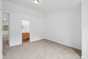 Carpeted bedroom with high ceilings and direct bathroom access at Roberts Court Townhomes in Gresham, Oregon