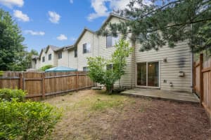 Concrete patio with sliding glass door and wood-fenced backyard at Roberts Court Townhomes in Gresham, Oregon
