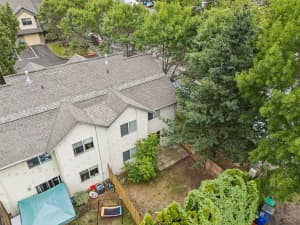 Aerial view of townhomes with fenced backyards and mature trees at Roberts Court Townhomes in Gresham, Oregon