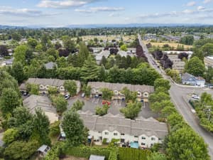 Aerial view of tree-lined townhomes with garages and rear patios at Roberts Court Townhomes in Gresham, Oregon