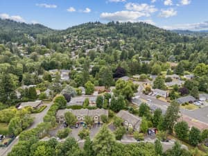 Aerial view of townhomes surrounded by trees and wooded hills at Roberts Court Townhomes in Gresham, Oregon