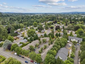 Aerial view of townhomes and parking areas amid a tree-filled neighborhood at Roberts Court Townhomes in Gresham, Oregon