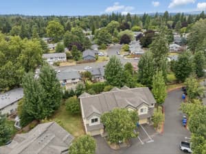 Aerial view of townhomes surrounded by mature trees and residential streets at Roberts Court Townhomes in Gresham, Oregon