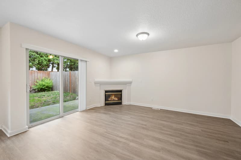Roberts Court townhome living room with fireplace, wood-look flooring, and sliding patio door
