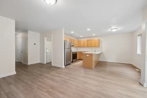 Open kitchen with light wood cabinets, white countertops, and a peninsula at Roberts Court Townhomes in Gresham, Oregon