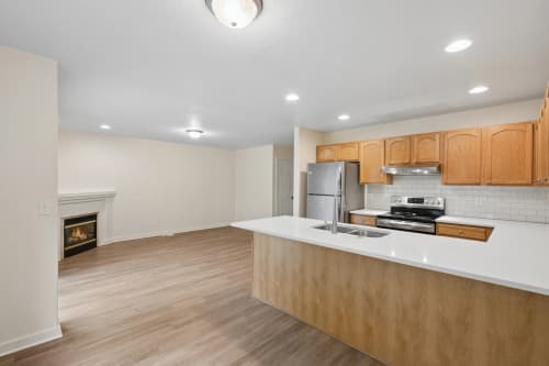 3-bedroom townhome kitchen peninsula with a view of the living room fireplace at Roberts Court Townhomes