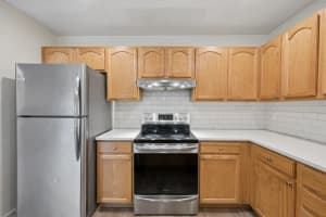 Kitchen with oak cabinets, white subway tile, and stainless steel appliances at Roberts Court Townhomes in Gresham, Oregon