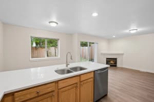 Kitchen breakfast bar overlooking a living area with fireplace at Roberts Court Townhomes in Gresham, Oregon