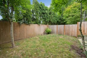 Grassy yard with tall wooden fencing and mature trees at Roberts Court Townhomes in Gresham, Oregon