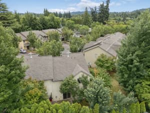 Aerial view of townhomes surrounded by mature trees and wooded hills at Roberts Court Townhomes in Gresham, Oregon