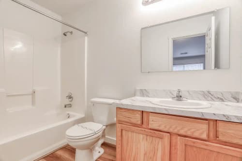 Updated bathroom with glass shower door and white vanity